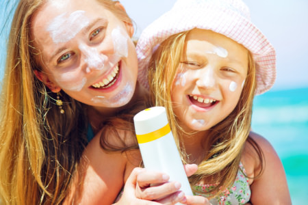 Sunscreen protection Mother and daughter with sunscreen