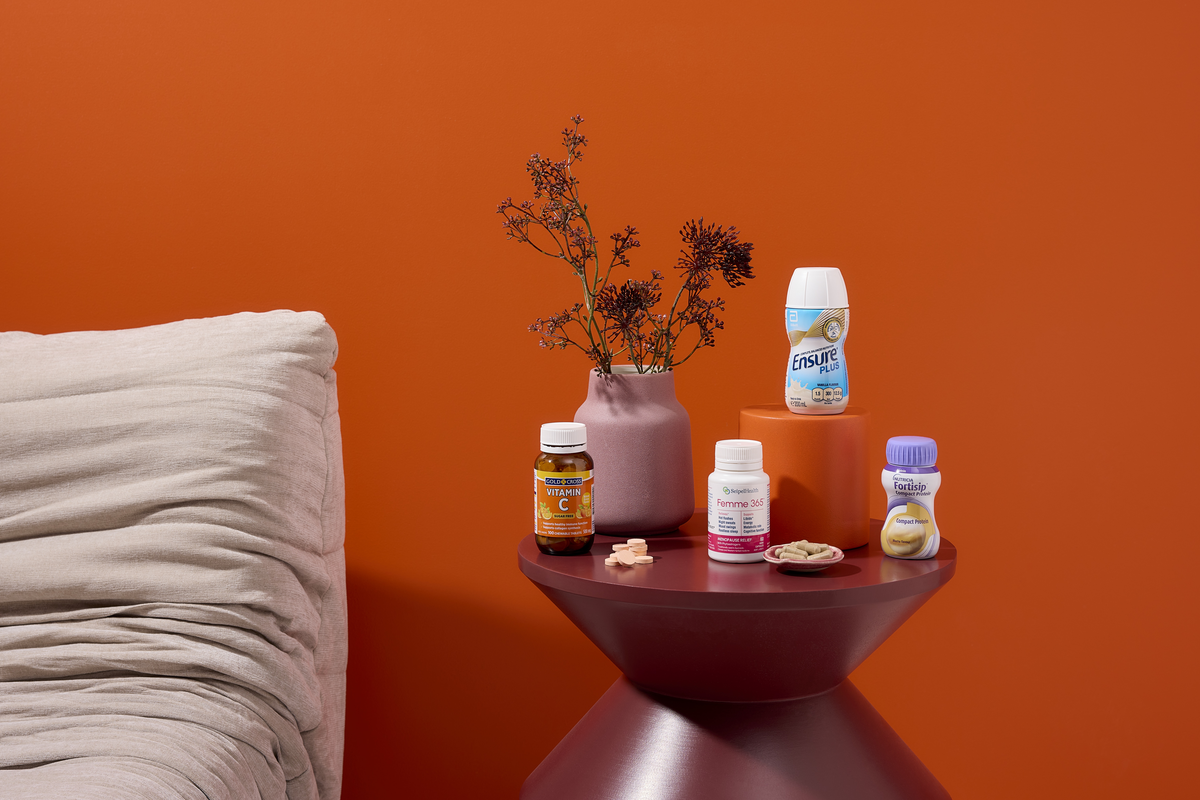 Nutritional supplements and oral nutrition drinks displayed on a bedside table.